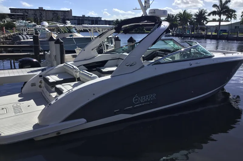 Slide: The Image of 2017 Regal 3200 Bowrider boat docked at marina, sunny day, palm trees in background. - 21