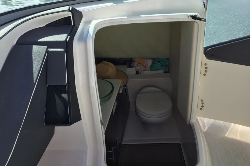 Slide: The Image of 2017 Regal 3200 Bowrider boat interior with compact bathroom and storage space. - 27