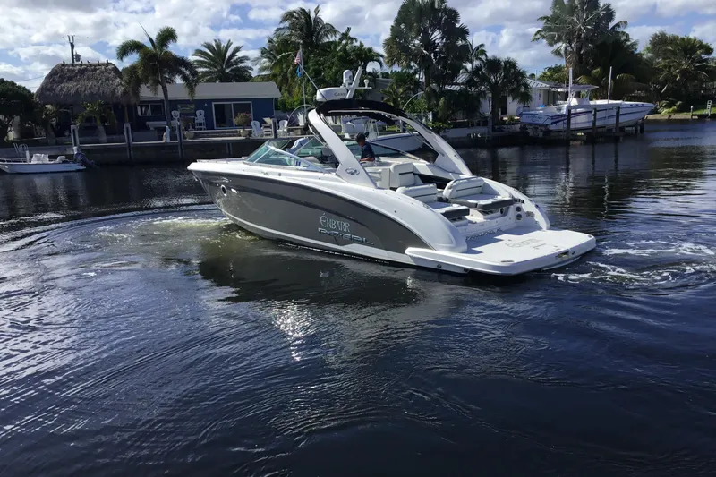 Slide: The Image of 2017 Regal 3200 Bowrider cruising on a calm waterway with palm trees in the background. - 3