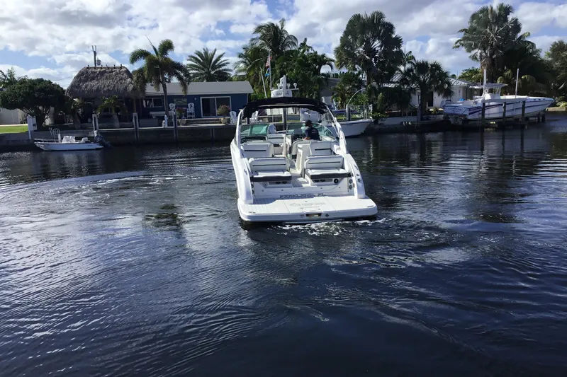 Slide: The Image of 2017 Regal 3200 Bowrider boat cruising on a calm, scenic waterway. - 4