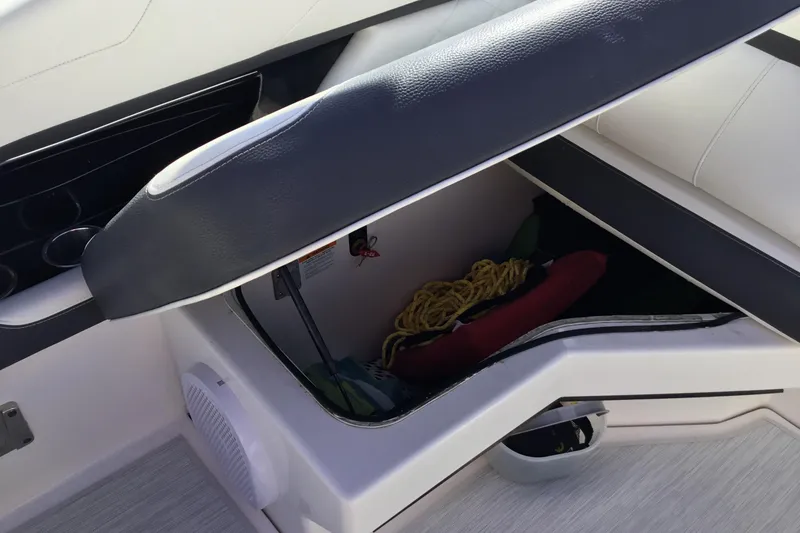 Slide: The Image of 2017 Regal 3200 Bowrider storage compartment with seat cushion lifted, revealing ropes and gear. - 41