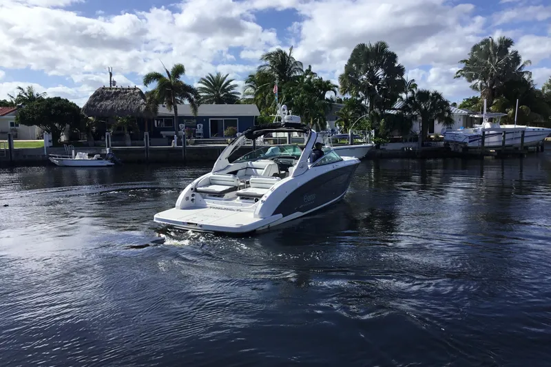 Slide: The Image of 2017 Regal 3200 Bowrider cruising on a sunny day near waterfront homes. - 5