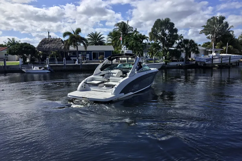 Slide: The Image of 2017 Regal 3200 Bowrider cruising on a scenic waterway with palm trees. - 6