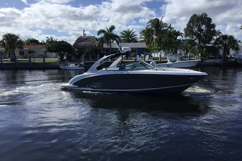 Slide: The Image of 2017 Regal 3200 Bowrider cruising on a sunny waterfront with palm trees. - 9