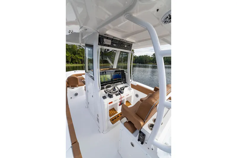 Slide: The Image of 2026 Sea Hunt Ultra 285 SE boat interior with modern helm and seating, on a serene lake. - 4