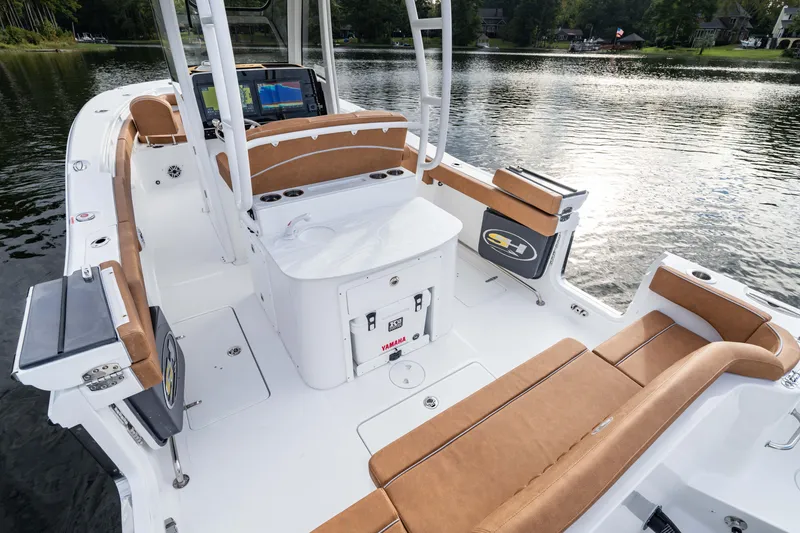 Slide: The Image of 2026 Sea Hunt Ultra 285 SE boat interior with tan seating on a serene lake. - 9
