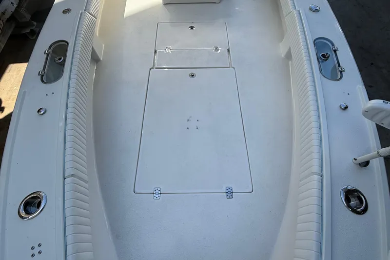 Slide: The Image of 2022 Dorado 25 Flat Deck boat interior with white seating and storage compartments. - 20