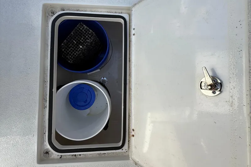 Slide: The Image of Storage compartment on 2022 Dorado 25 Flat Deck boat with buckets and latch. - 26