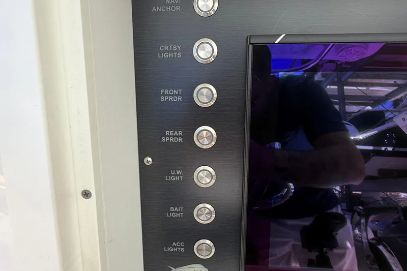 Slide: The Image of Control panel of 2022 Dorado 25 Flat Deck boat with various light switches. - 38