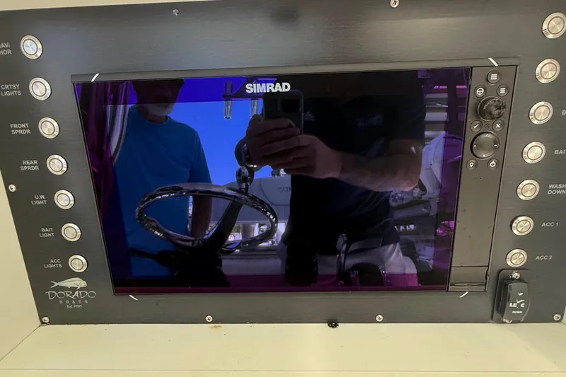 Slide: The Image of Control panel of 2022 Dorado 25 Flat Deck boat with Simrad display and various switches. - 39