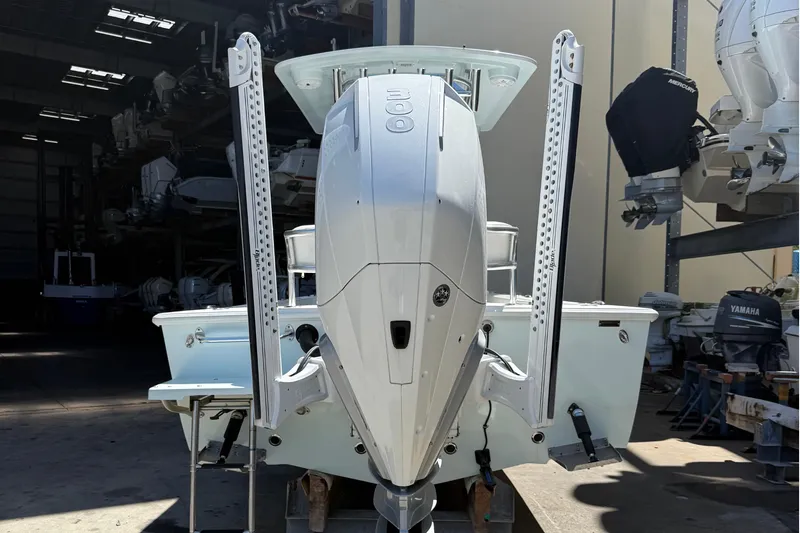 Slide: The Image of 2022 Dorado 25 Flat Deck boat with powerful outboard motor in a storage facility. - 4