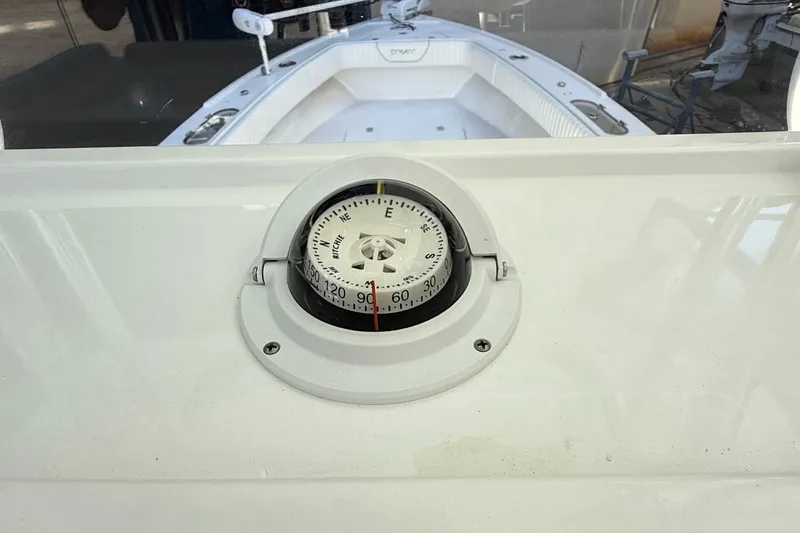 Slide: The Image of Compass on 2022 Dorado 25 Flat Deck boat, white interior visible. - 41