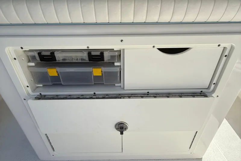 Slide: The Image of Storage compartment on 2022 Dorado 25 Flat Deck boat with organized tackle boxes. - 49