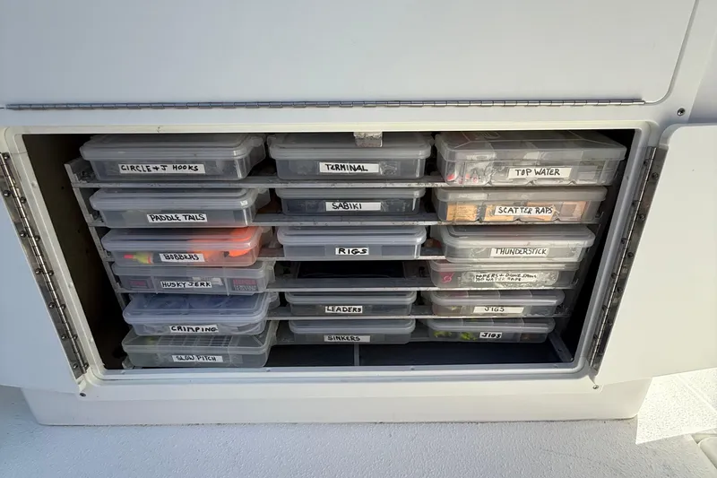 Slide: The Image of Fishing tackle storage on 2022 Dorado 25 Flat Deck boat, organized with labeled boxes. - 54