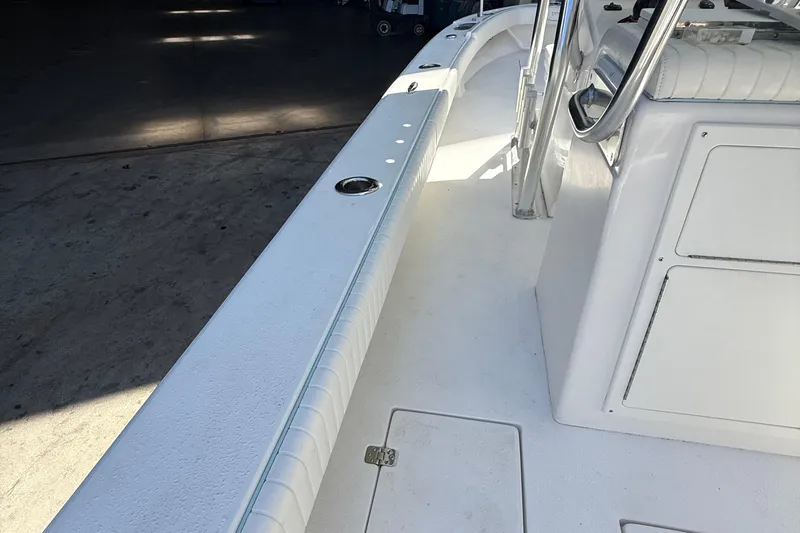Slide: The Image of 2022 Dorado 25 Flat Deck boat interior with white seating and storage compartments. - 59