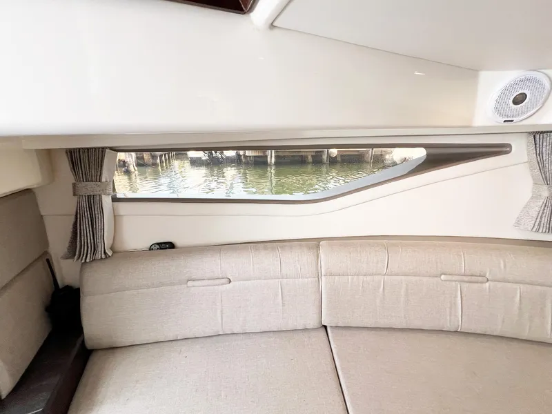 Slide: The Image of Interior of 2019 Sea Ray Sundancer 320 Outboard with beige seating and window view. - 18