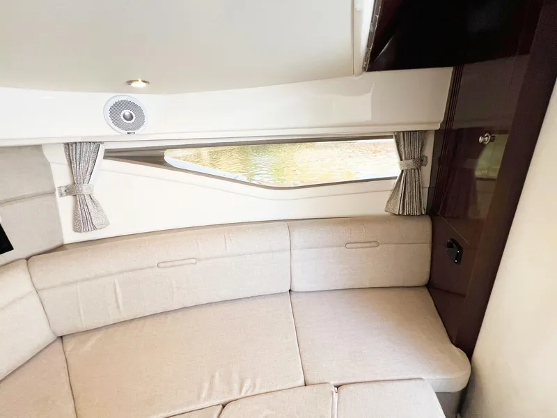 Slide: The Image of Interior of 2019 Sea Ray Sundancer 320 Outboard with beige seating and window view. - 19