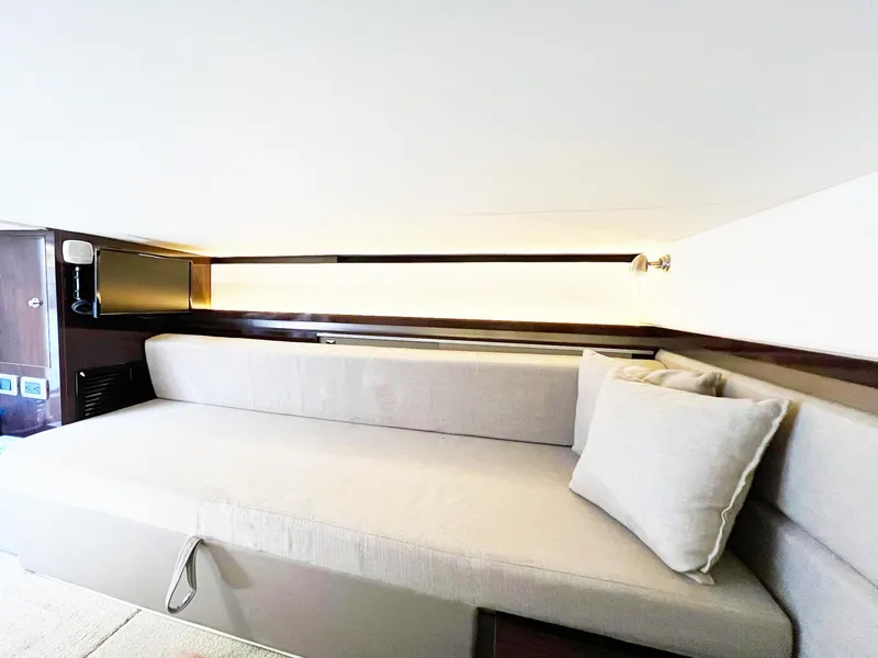 Slide: The Image of 2019 Sea Ray Sundancer 320 Outboard interior with a comfortable beige sofa and modern lighting. - 21