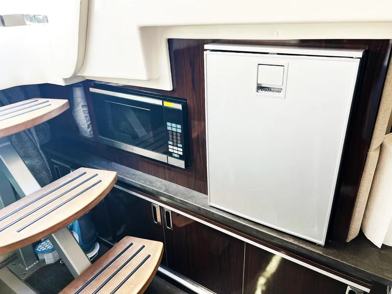 Slide: The Image of 2019 Sea Ray Sundancer 320 Outboard interior with microwave and fridge. - 23
