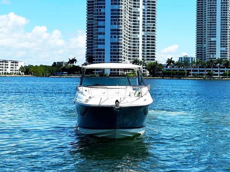 Slide: The Image of 2019 Sea Ray Sundancer 320 Outboard on water with city skyline backdrop. - 3