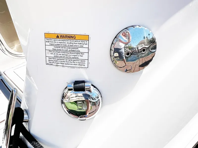 Slide: The Image of 2019 Sea Ray Sundancer 320 Outboard fuel cap and warning label on white hull. - 35