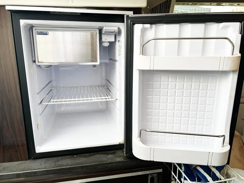 Slide: The Image of Open mini fridge inside 2019 Sea Ray Sundancer 320 Outboard boat, showing empty shelves. - 45