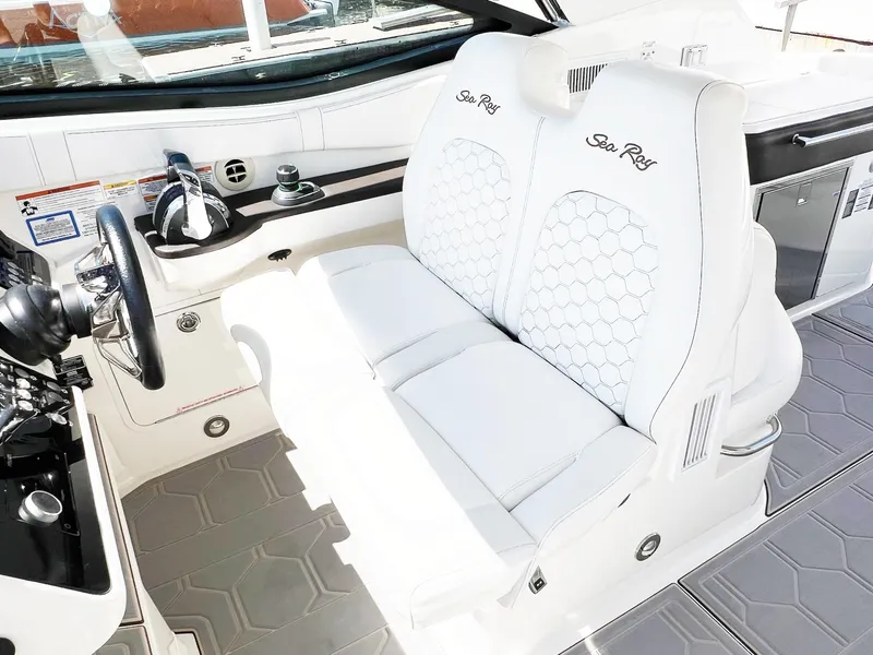 Slide: The Image of 2019 Sea Ray Sundancer 320 Outboard cockpit with white leather seating and modern controls. - 7