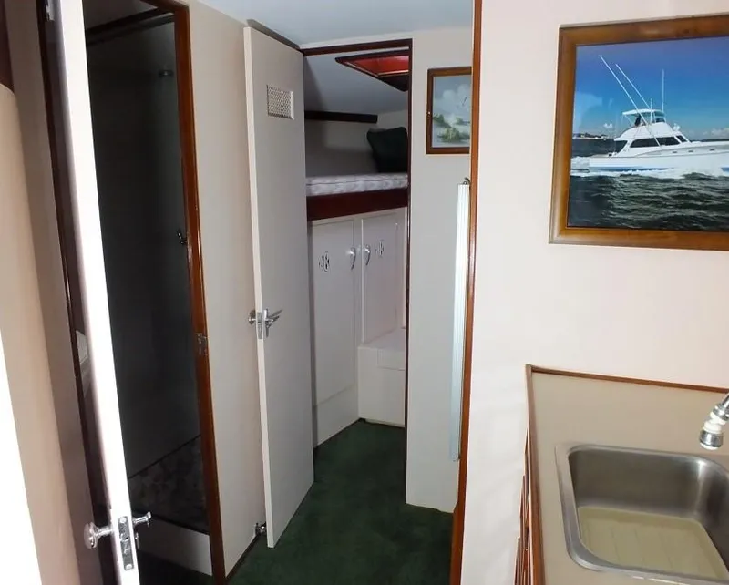 Slide: The Image of 1957 Rybovich Convertible interior with sink, cabinets, and framed boat picture. - 11