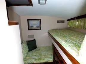 Slide: The Image of 1957 Rybovich Convertible cabin with bunk beds and nautical decor. - 14
