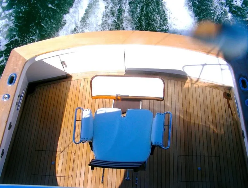 Slide: The Image of 1957 Rybovich Convertible boat deck with wooden flooring and fishing chair. - 18