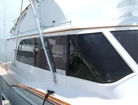 Slide: The Image of 1957 Rybovich Convertible boat with sleek design and large windows at a dock. - 2