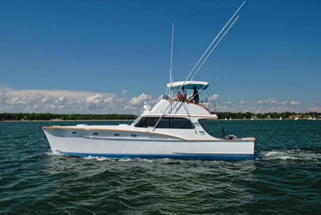Slide: The Image of 1957 Rybovich Convertible yacht cruising on open water under clear blue skies. - 24
