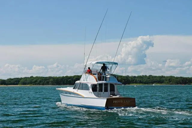Slide: The Image of 1957 Rybovich Convertible boat cruising on a sunny day with two people onboard. - 27