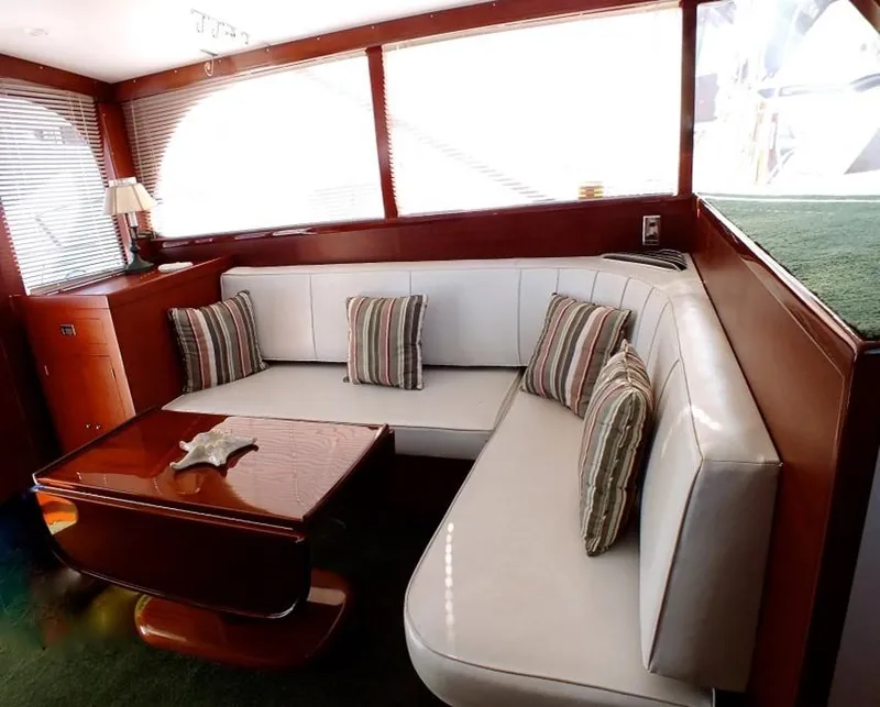 Slide: The Image of 1957 Rybovich Convertible yacht interior with white leather seating and striped cushions. - 7