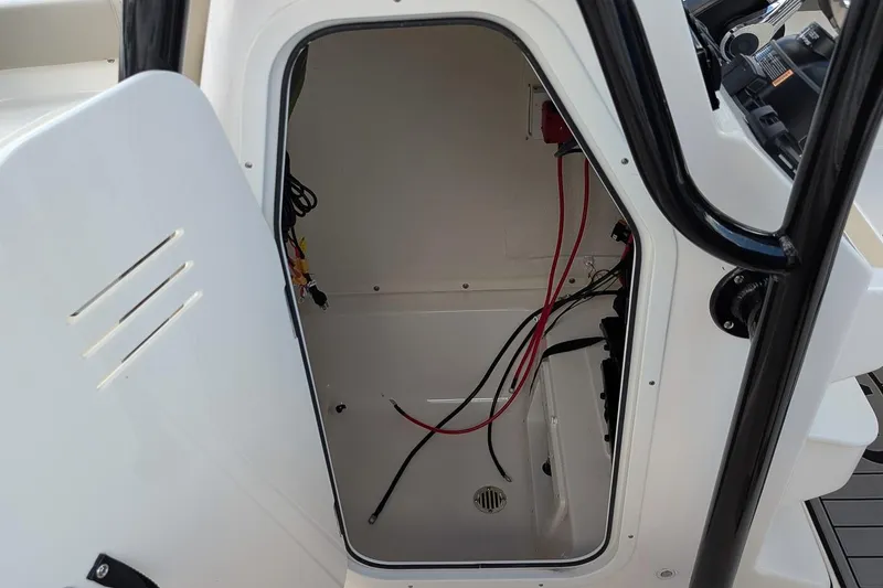 Slide: The Image of Open storage compartment on 2025 Key West 239 FS boat, showing interior wiring. - 16