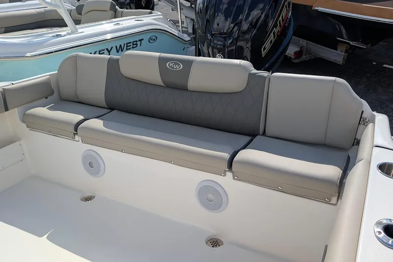 Slide: The Image of 2025 Key West 239 FS boat interior with cushioned seating and built-in speakers. - 9