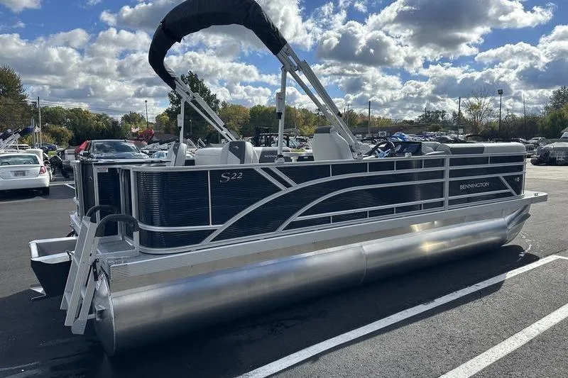 Slide: The Image of 2026 Bennington 22 SF pontoon boat, front view, parked outdoors under cloudy sky. - 2