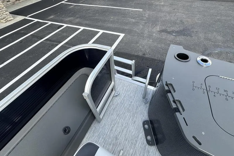 Slide: The Image of 2026 Bennington 22 SF boat interior with seating and control panel, parked on asphalt. - 38