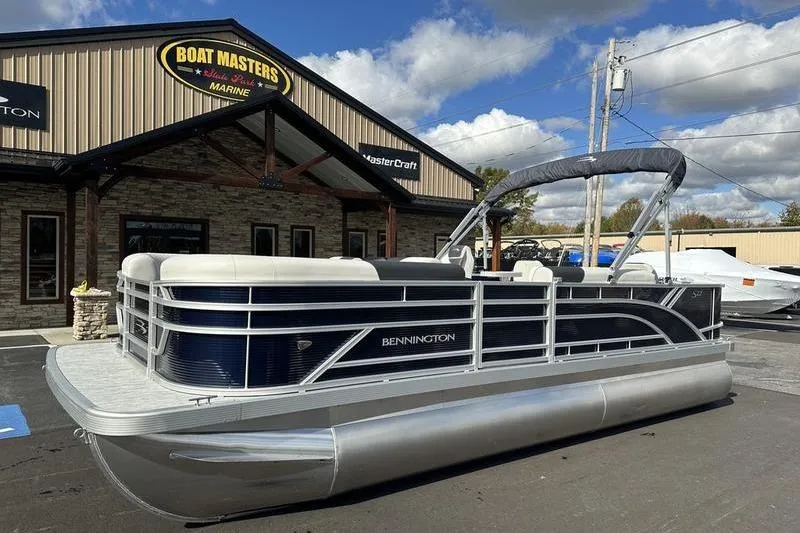 Slide: The Image of 2026 Bennington 22 SF pontoon boat, rear view in a parking lot, under a cloudy sky. - 6