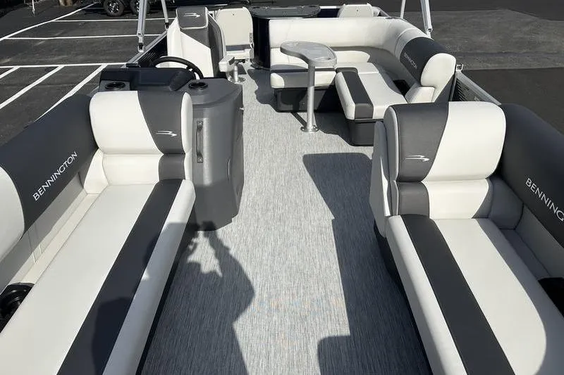 Slide: The Image of 2026 Bennington 22 SF pontoon boat parked under a cloudy sky. - 7