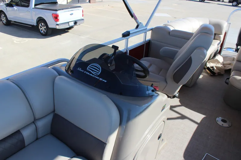 Slide: The Image of 2023 Sun Tracker Party Barge 22 RF DLX interior with plush seating and steering console. - 9