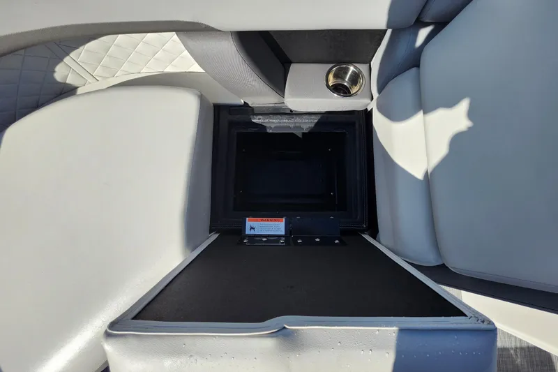 Slide: The Image of Open storage compartment in 2026 Lowe SS 230 DV boat with cup holder and cushioned seating. - 13