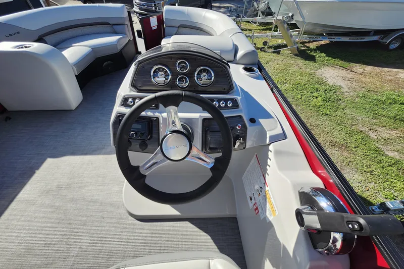 Slide: The Image of 2026 Lowe SS 230 DV boat dashboard with steering wheel and gauges in a sunny outdoor setting. - 19