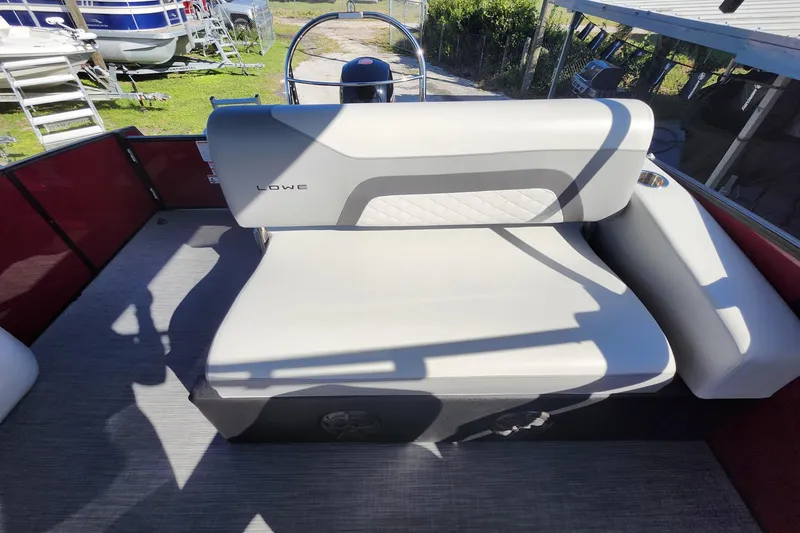 Slide: The Image of 2026 Lowe SS 230 DV boat interior with cushioned seating and steering wheel. - 24