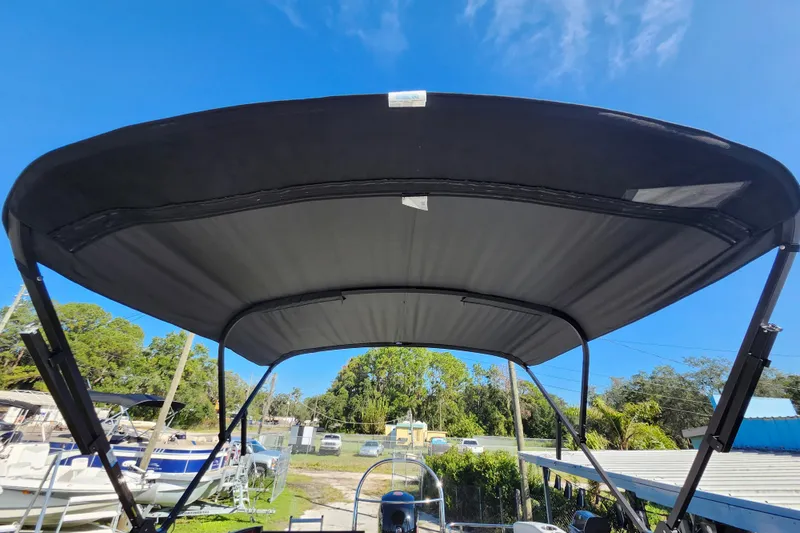 Slide: The Image of 2026 Lowe SS 230 DV boat with black canopy under clear blue sky. - 28