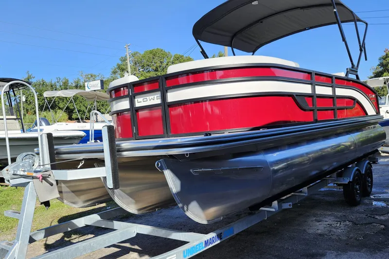 Slide: The Image of 2026 Lowe SS 230 DV pontoon boat with red and white design on a trailer. - 3
