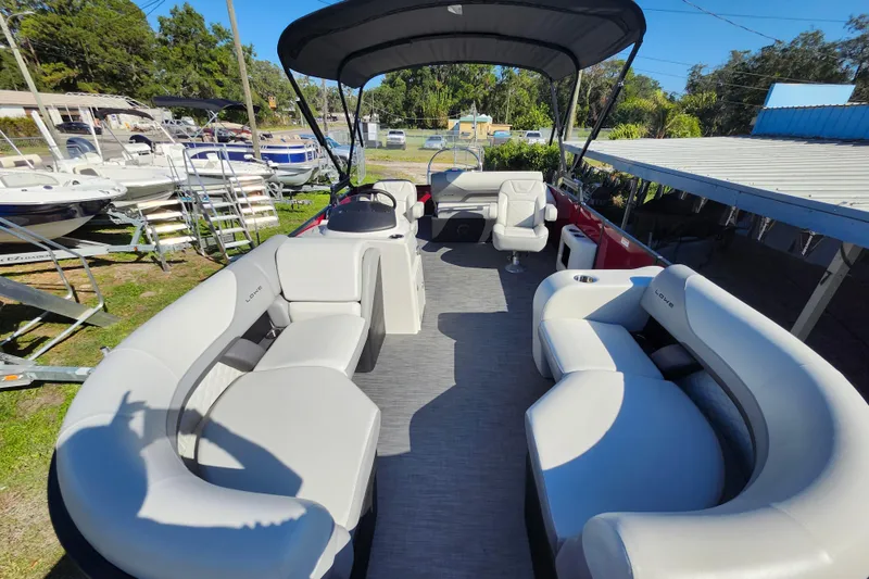 Slide: The Image of 2026 Lowe SS 230 DV pontoon boat with spacious seating and canopy in a marina setting. - 31