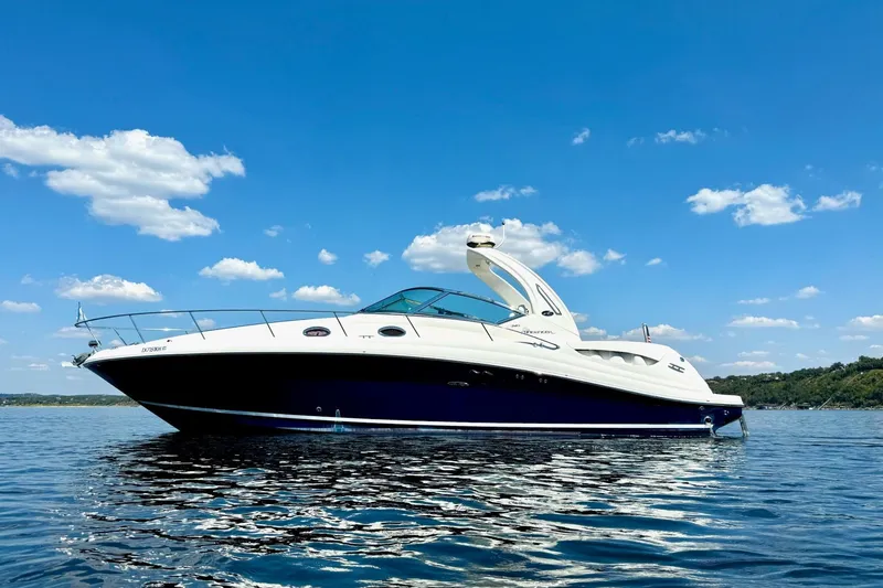 Slide: The Image of 2005 Sea Ray 340 Sundancer yacht on calm water under a clear blue sky. - 1