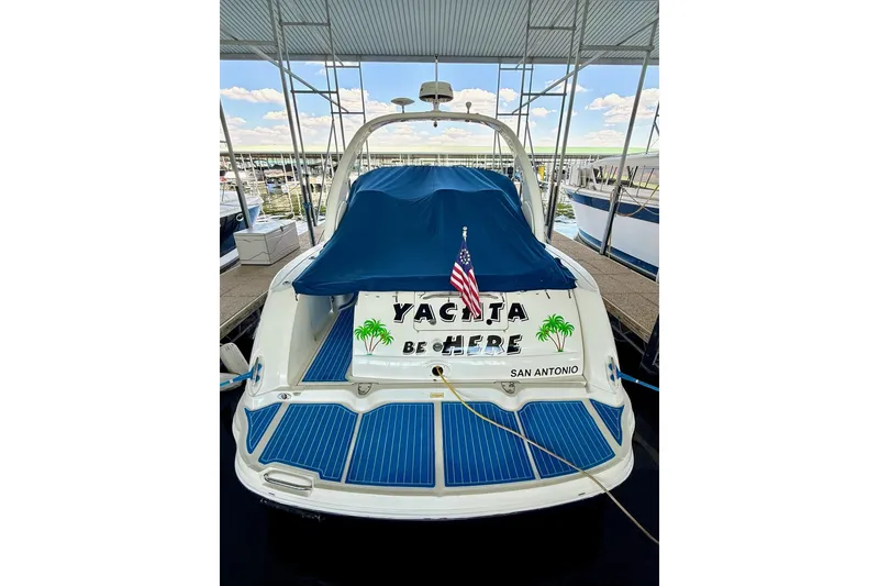 Slide: The Image of 2005 Sea Ray 340 Sundancer docked with blue cover and American flag. - 11