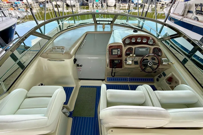 Slide: The Image of 2005 Sea Ray 340 Sundancer cockpit with steering wheel, gauges, and white seating. - 15